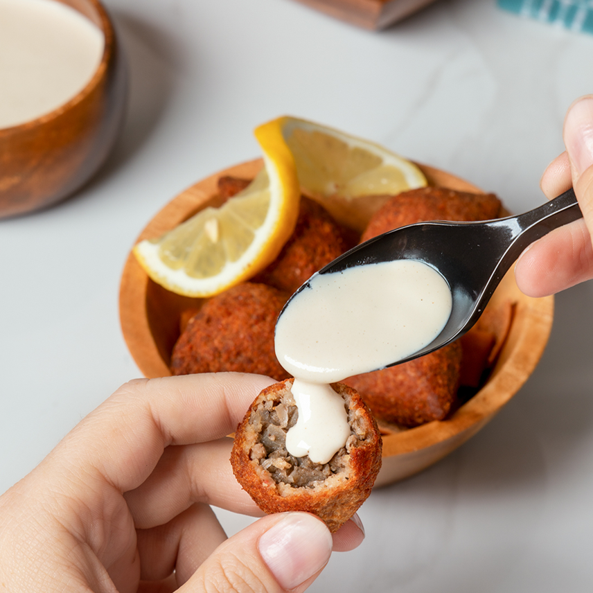 Kibbeh with tahini served by spoon